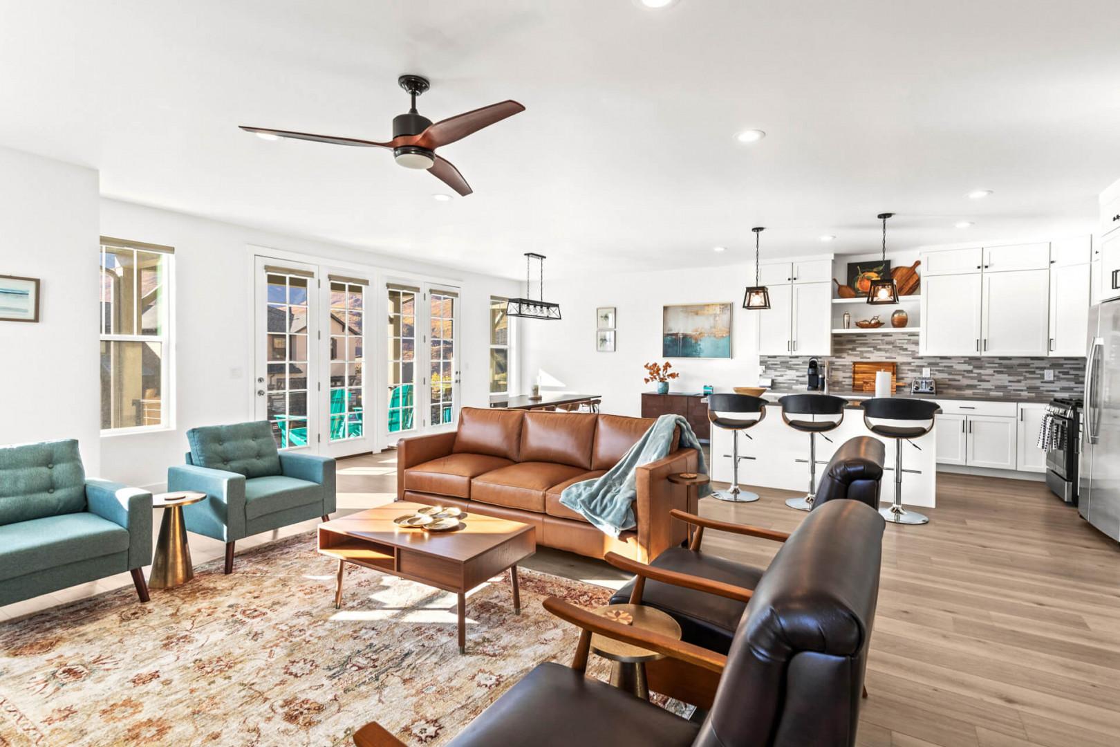 Relax in your open-concept living space where modern comfort meets thoughtful design. Sink into the leather sofas, enjoy the sleek kitchen, and let natural light pour through French doors that open to your private outdoor area.