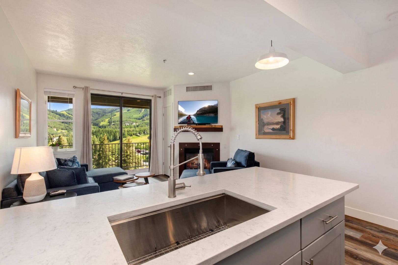 Picture yourself unwinding here after a day of adventure—sink into plush seating by your cozy fireplace while mountain vistas unfold through the balcony doors, blending alpine charm with modern comforts in your inviting retreat.