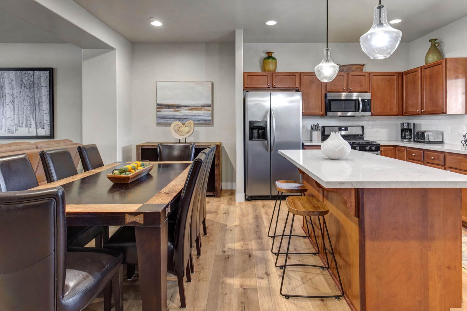 Your open-concept kitchen and dining area invites memorable meals with modern appliances, warm wood cabinetry, and elegant pendant lighting creating the perfect gathering space.