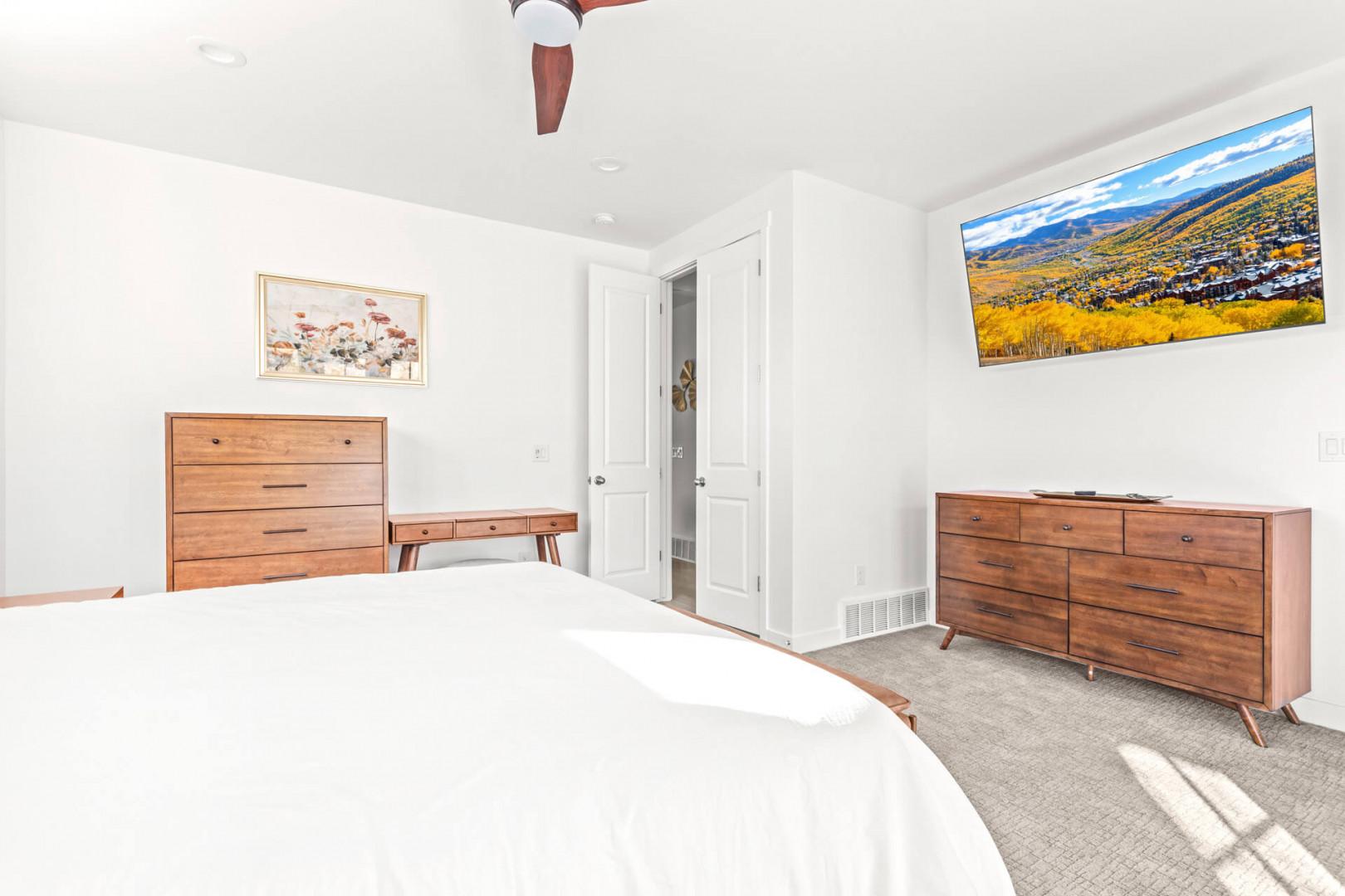 Drift off in your serene bedroom, where warm wood tones and crisp linens invite restful sleep, with mountain views framed on the wall to inspire your next adventure.