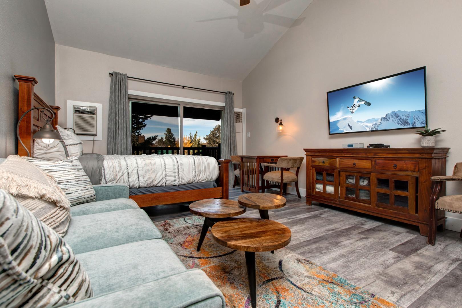 Cozy space with queen bed, sofa bed, TV, and dining area.