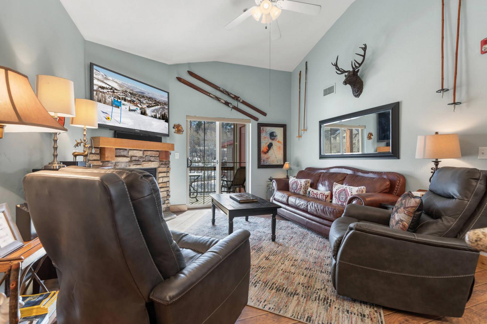 Bear Hollow Lodge 1401: A luxe leather sofa (with pull-out Queen-sized bed) and two relaxing recliners face the mounted HDTV and rustic stone fireplace.