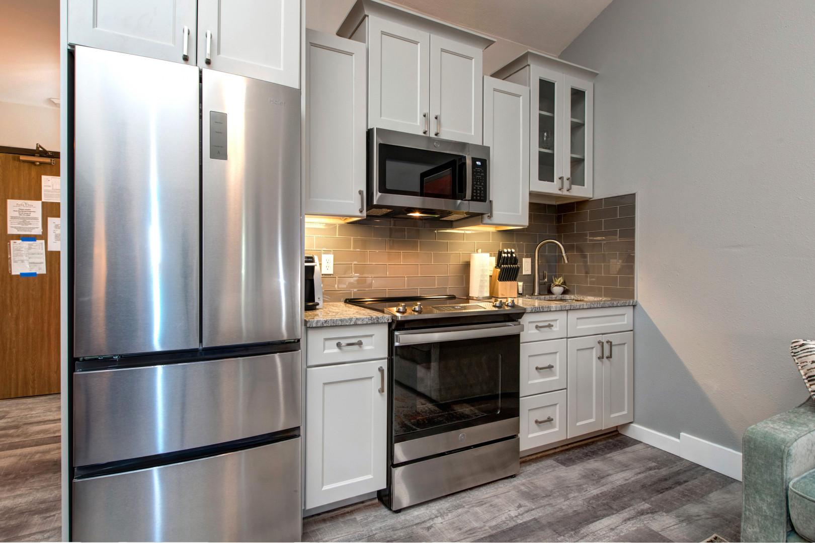 sleek electric range, fridge, microwave, ample cabinets, and countertops.