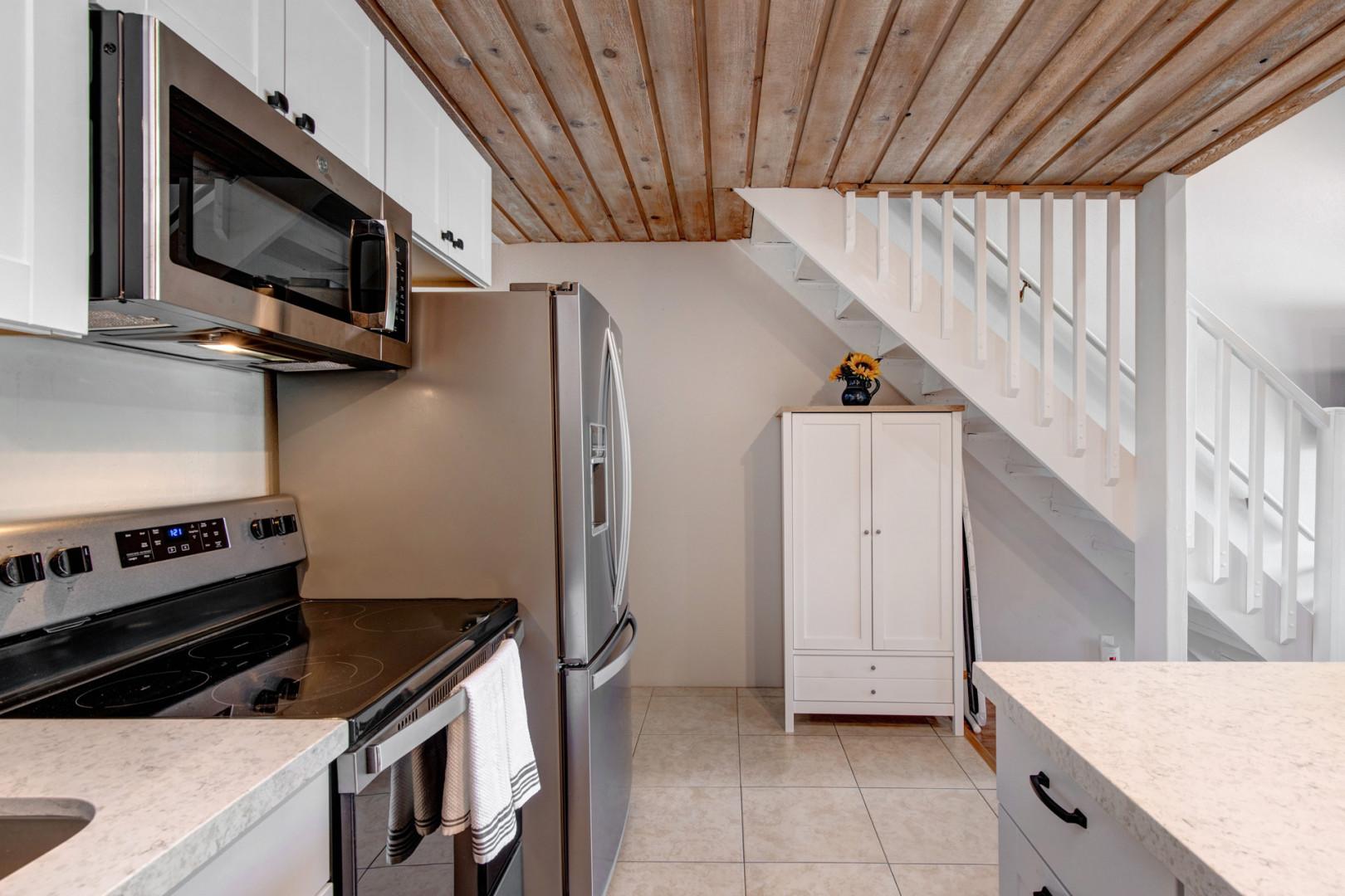 Modern electric range and refrigerator in a sleek kitchen setup.