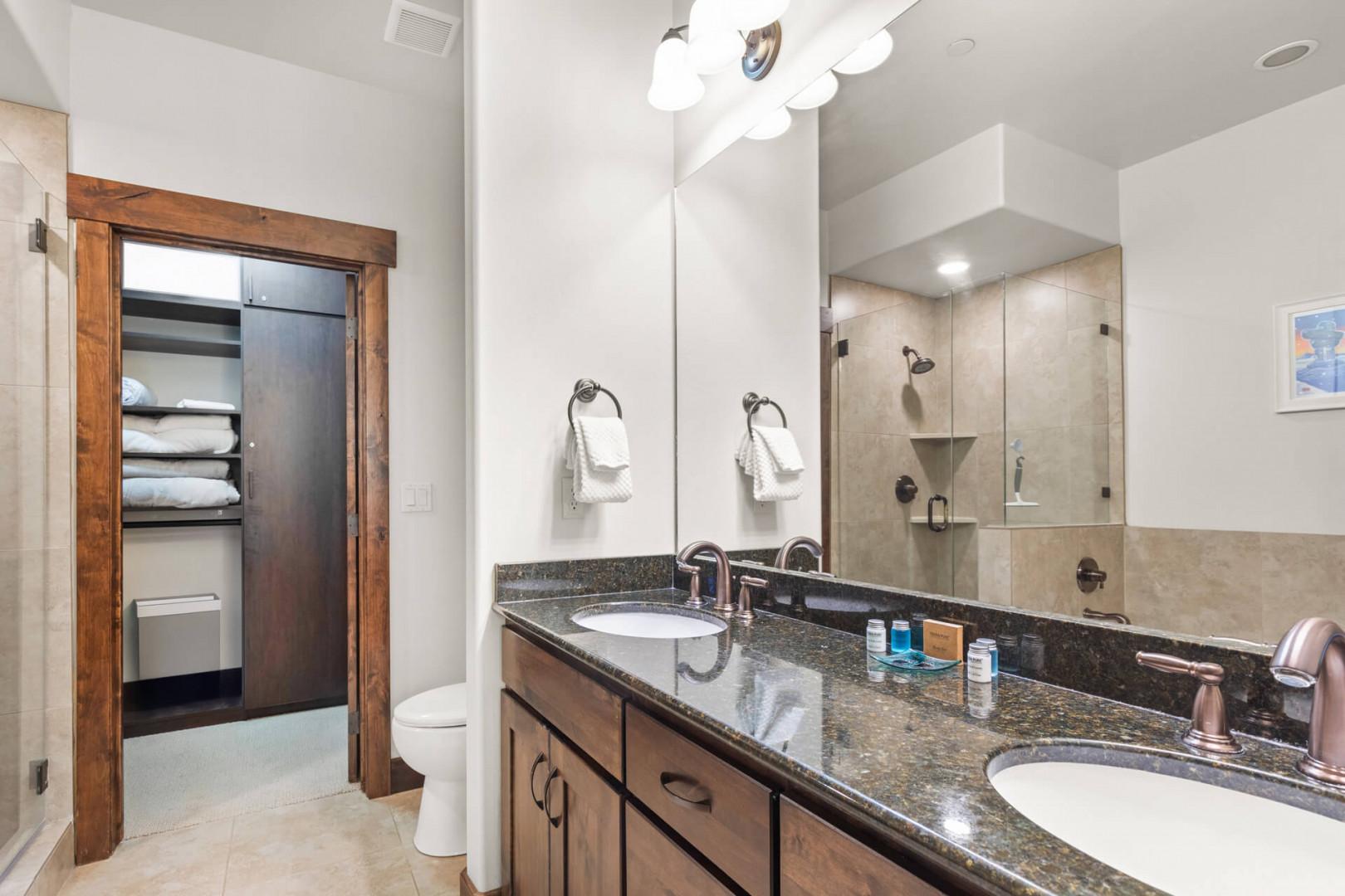 Luxurious granite vanity with dual sinks awaits your morning routine, while your spacious walk-in shower promises relaxing evenings.