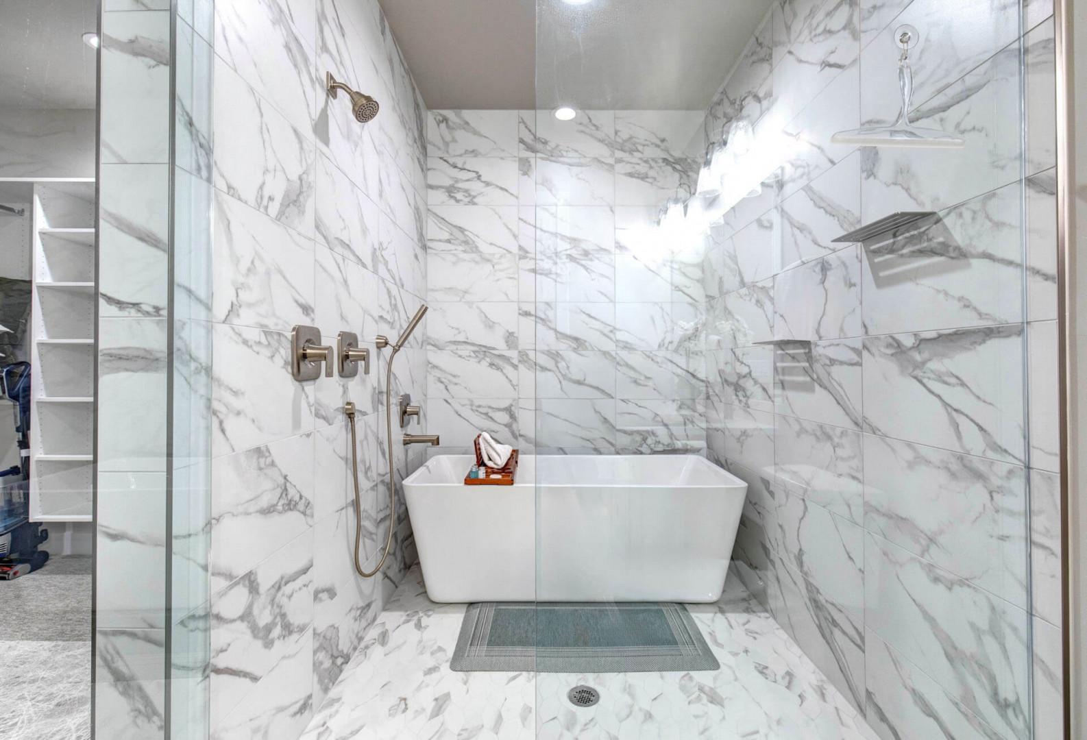Luxurious marble-wrapped wet room featuring a sleek freestanding tub and modern fixtures—your private spa retreat awaits.
