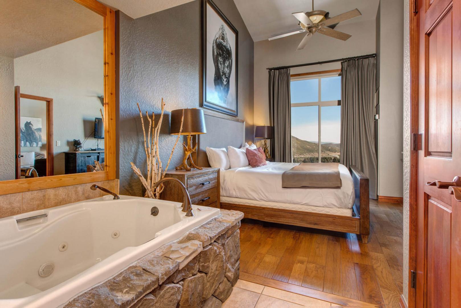 Serene retreat with king bed, window view, and tub nearby.