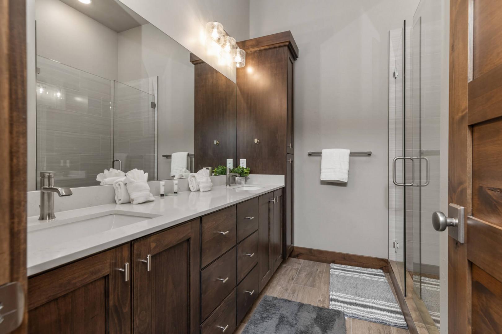 Modern sink and spacious shower area in this cozy room.