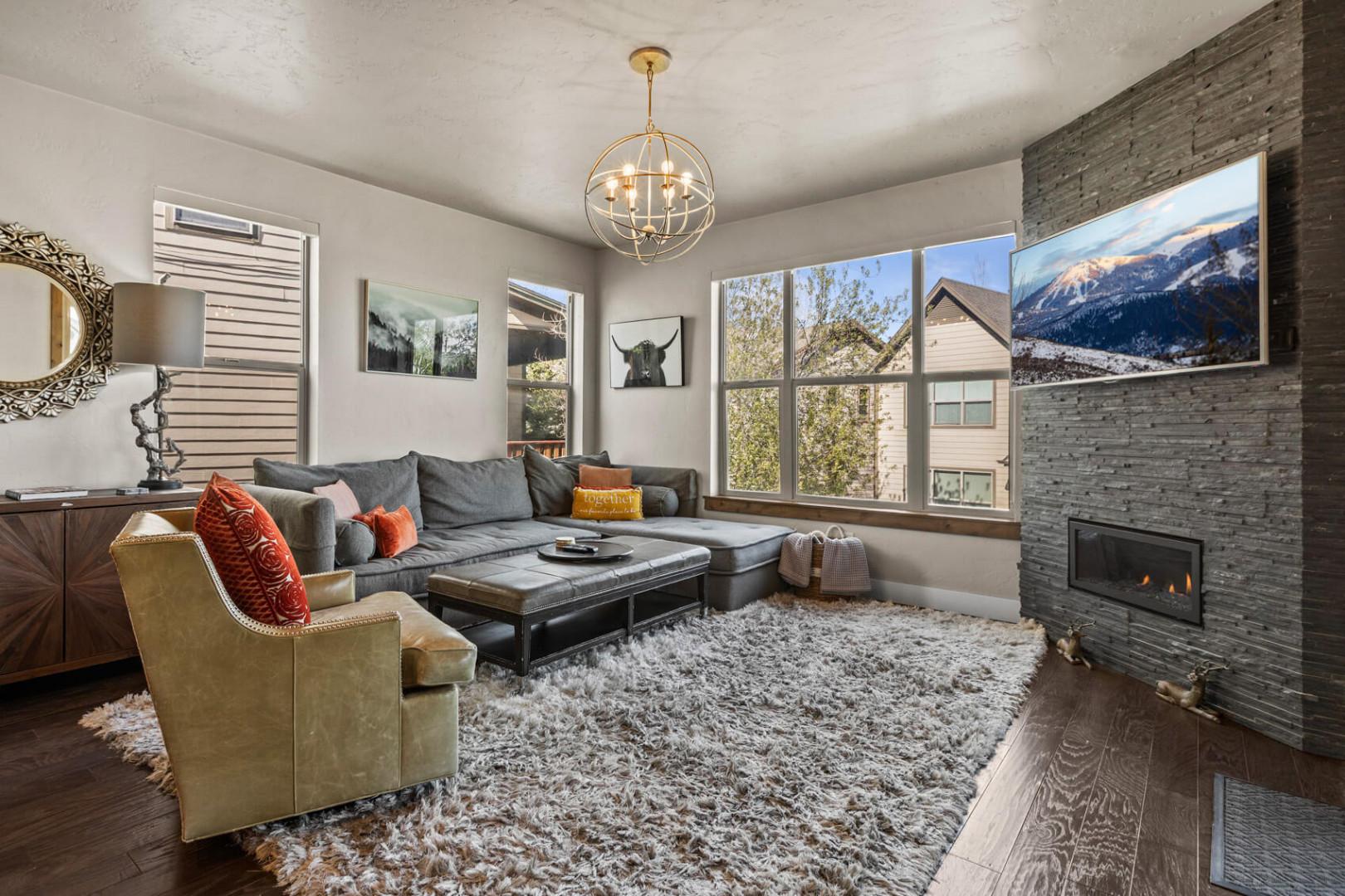 Sink into plush seating by your cozy fireplace while mountain views frame your relaxation through expansive windows.