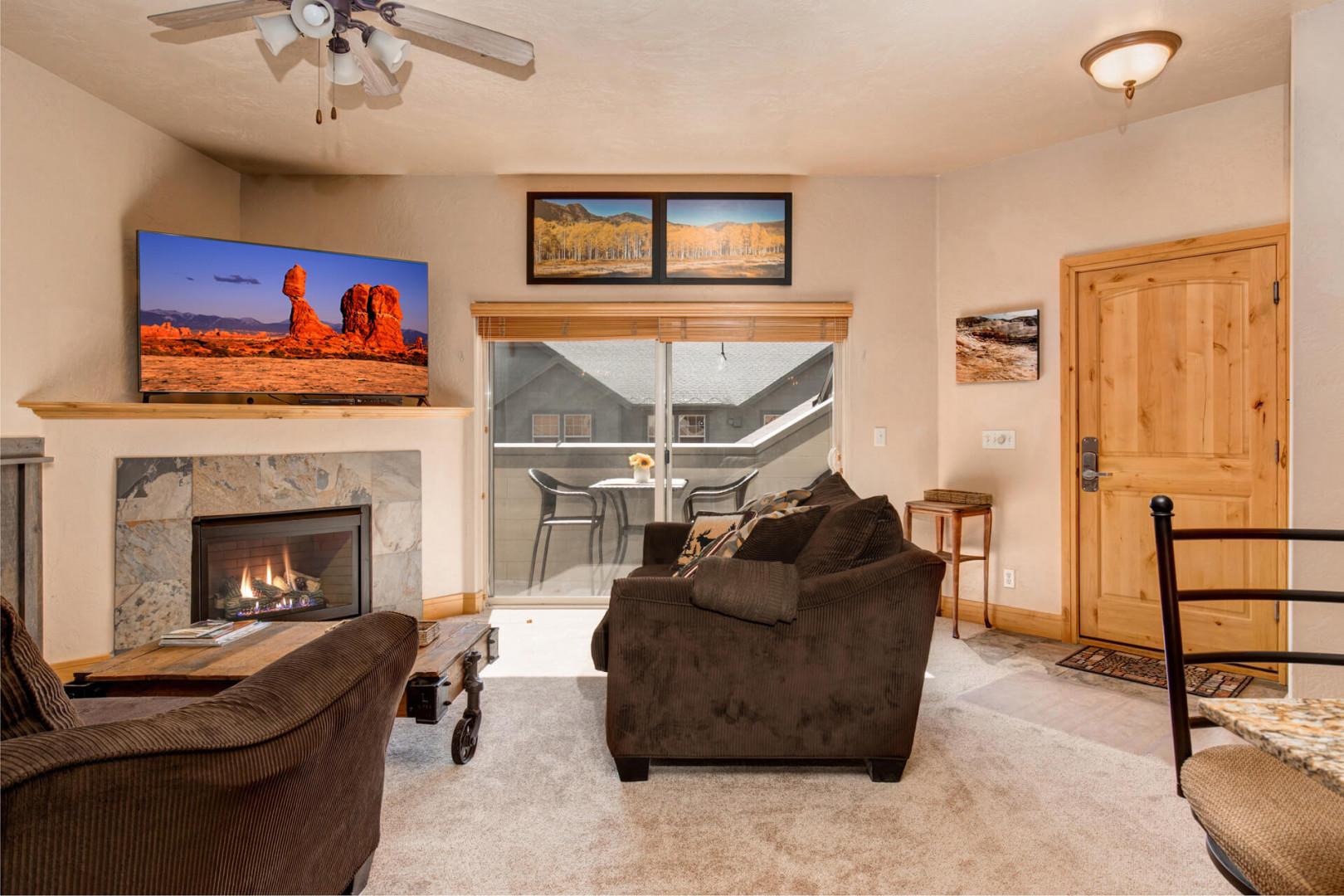 1684 Fox Hollow #H3_14: Cozy sofa set by the fireplace, leading to a charming outdoor patio.