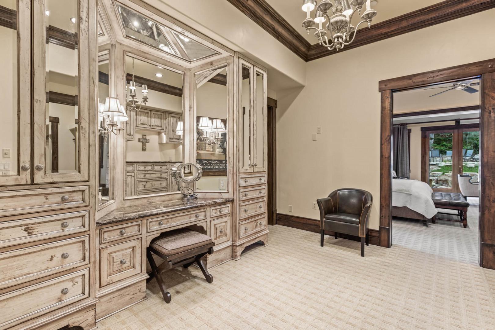 Elegant dressing room with huge mirrors and cabinets.