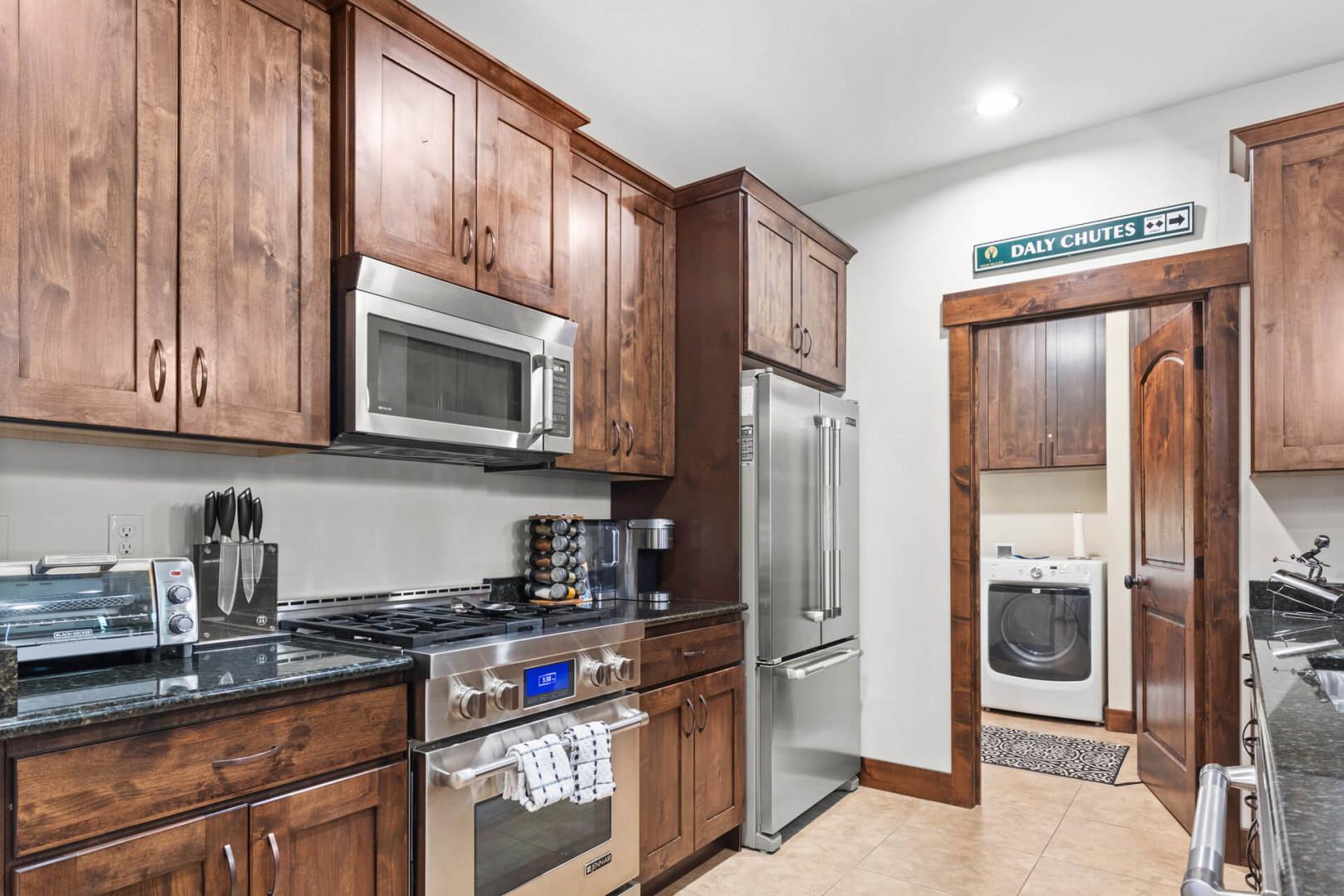 Your gourmet kitchen features rich wood cabinetry, granite countertops, and premium stainless steel appliances for effortless meal preparation.