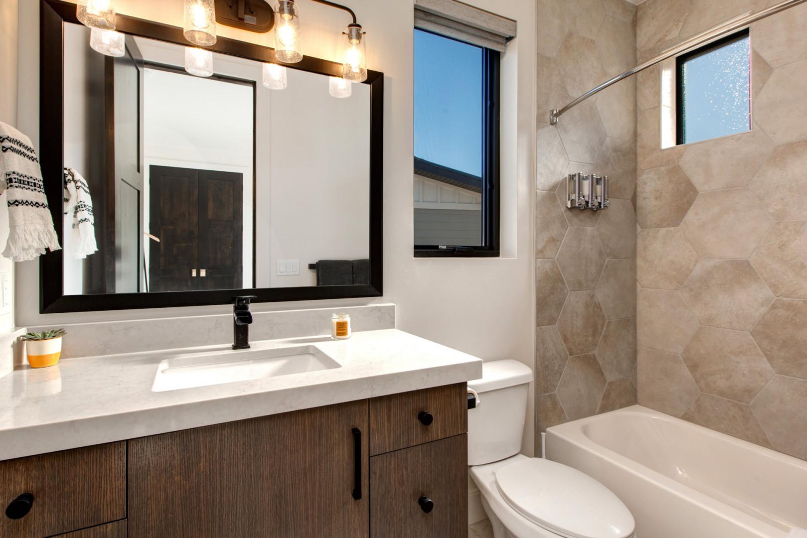 Jordanelle Estates 13201: Sleek sink, mirror, toilet, and convenient tub shower combo.