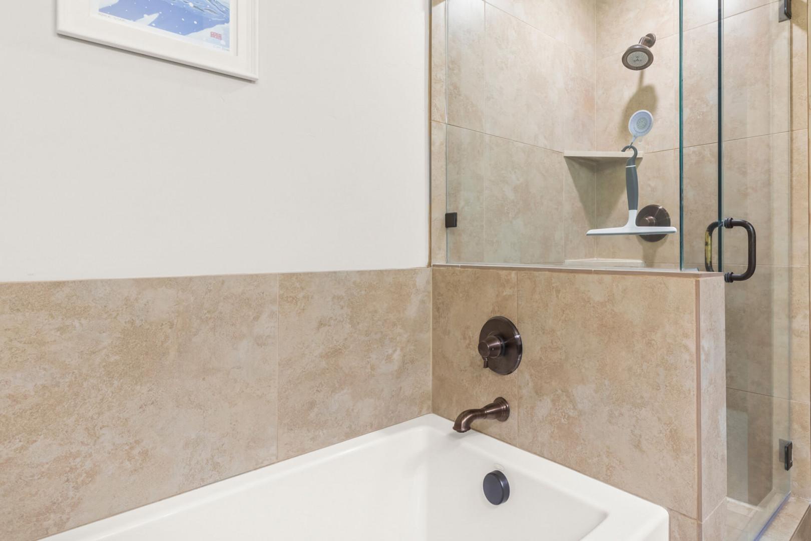 Unwind in your elegant bathroom with a luxurious soaking tub and separate glass-enclosed shower, perfect for your daily refresh.