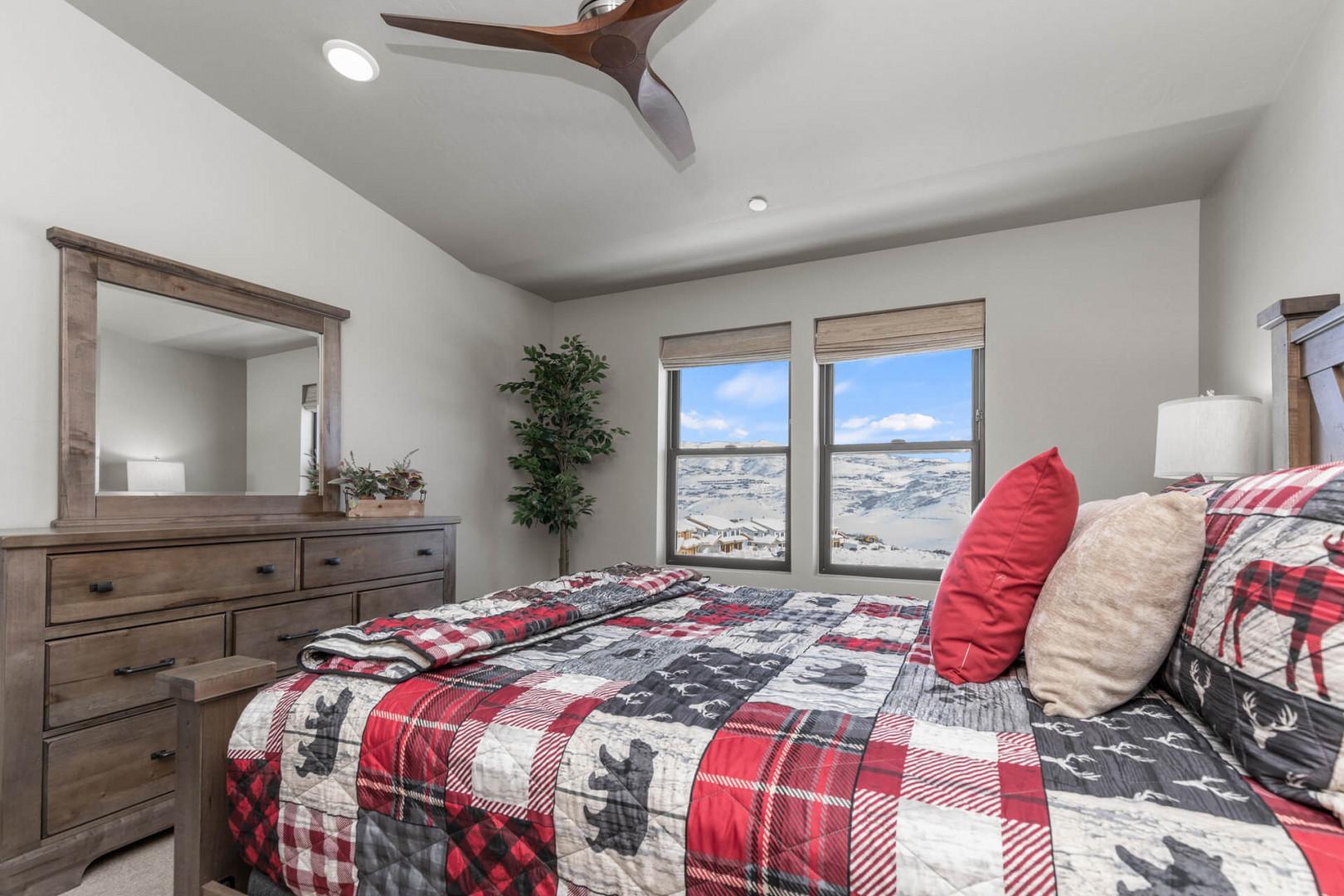 Cozy bed bathed in natural light from the large windows.