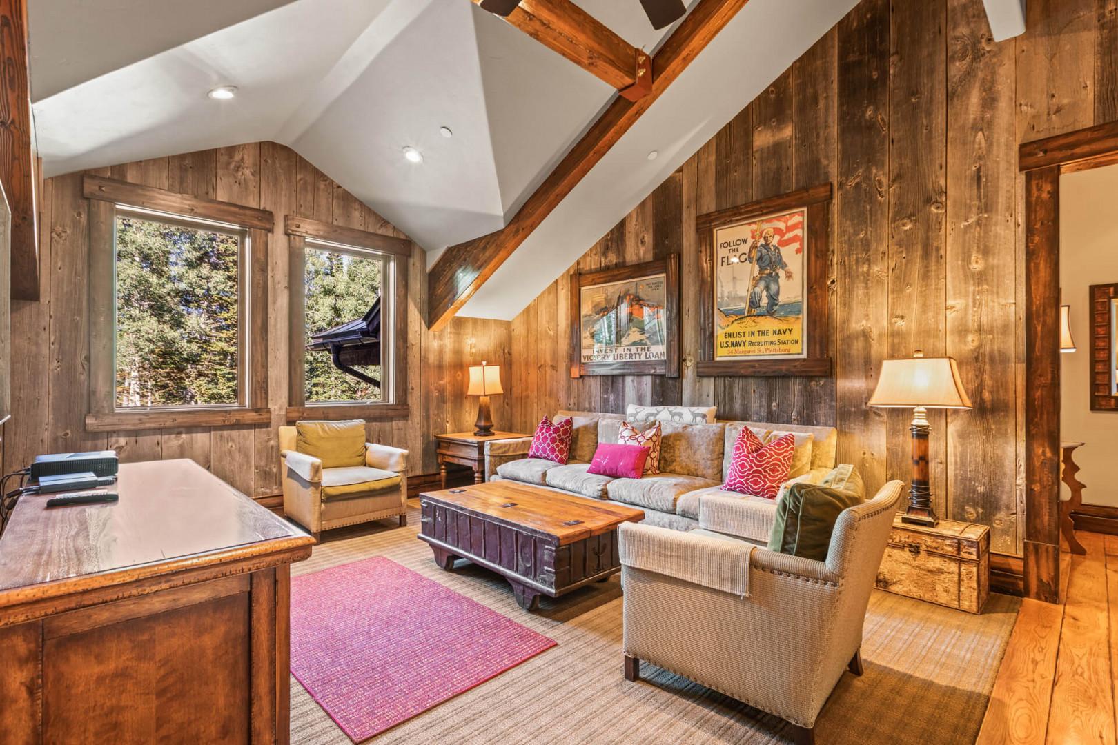 Cozy sofa set, center table, windows, and mounted TV view.