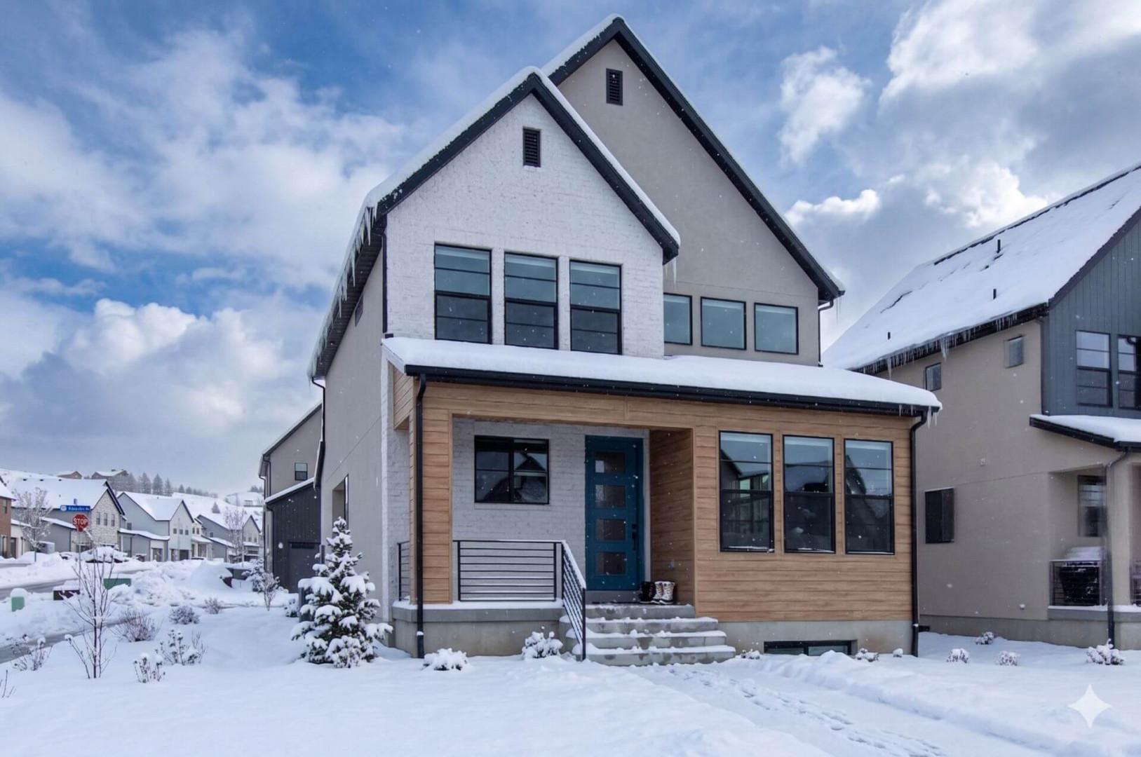 Modern mountain retreat with distinctive architecture set in a pristine winter landscape with snow-covered surroundings.