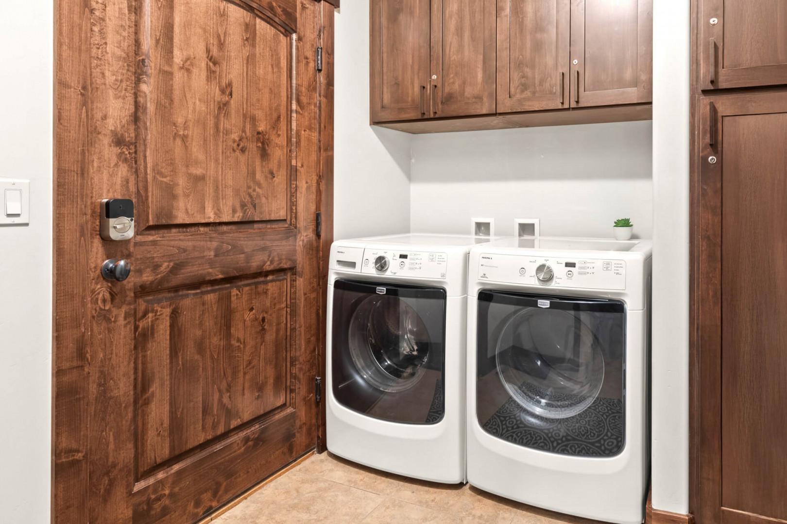 Your own dedicated laundry room features full-size washer and dryer with beautiful wood cabinetry for all your storage needs.