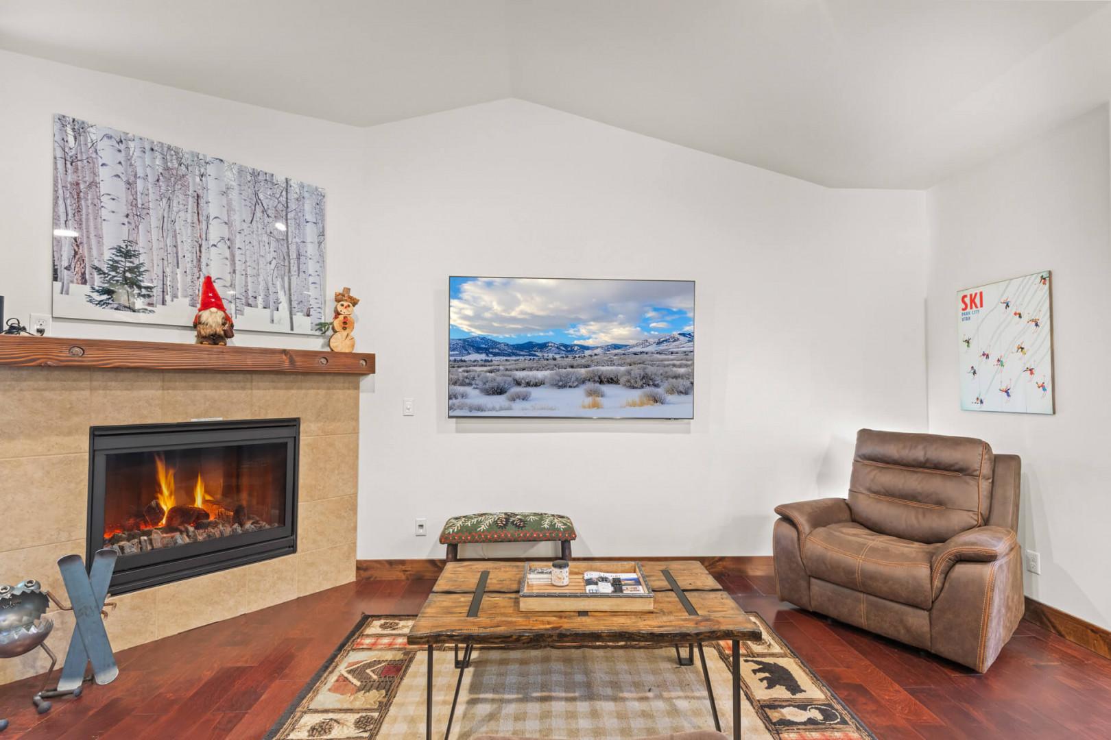 Cozy up in your mountain retreat's living room with a crackling fireplace, leather armchair, and ski-themed art surrounding you.