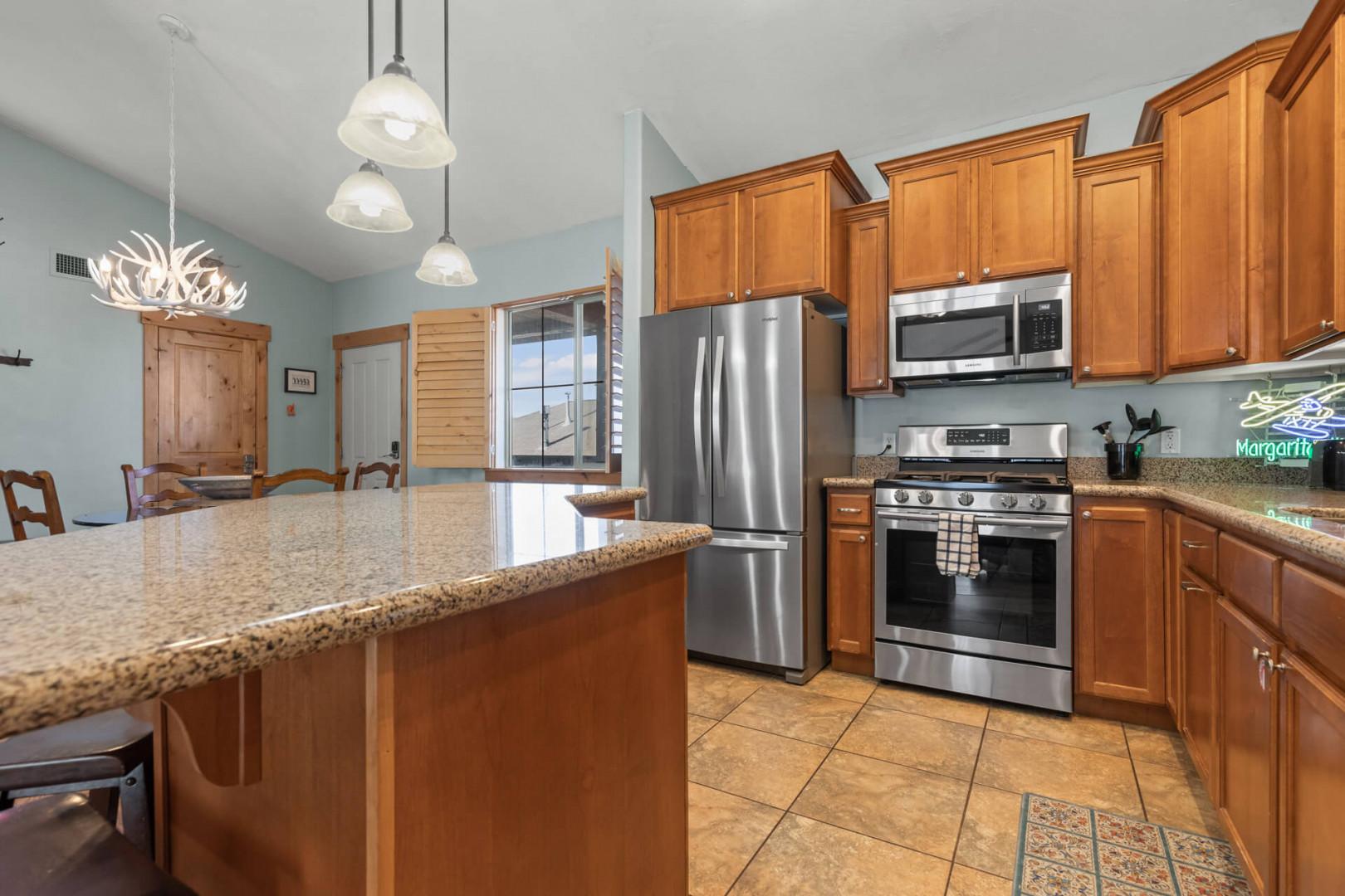 Bear Hollow Lodge 1401: Gleaming granite countertops with tons of workspace; A curved island with bar stool seating leads into the open kitchen; A perfect location for snacks, meals or games.