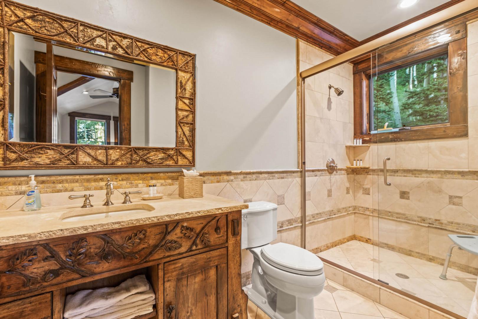 Sleek sink, mirror, toilet, and shower in modern design.