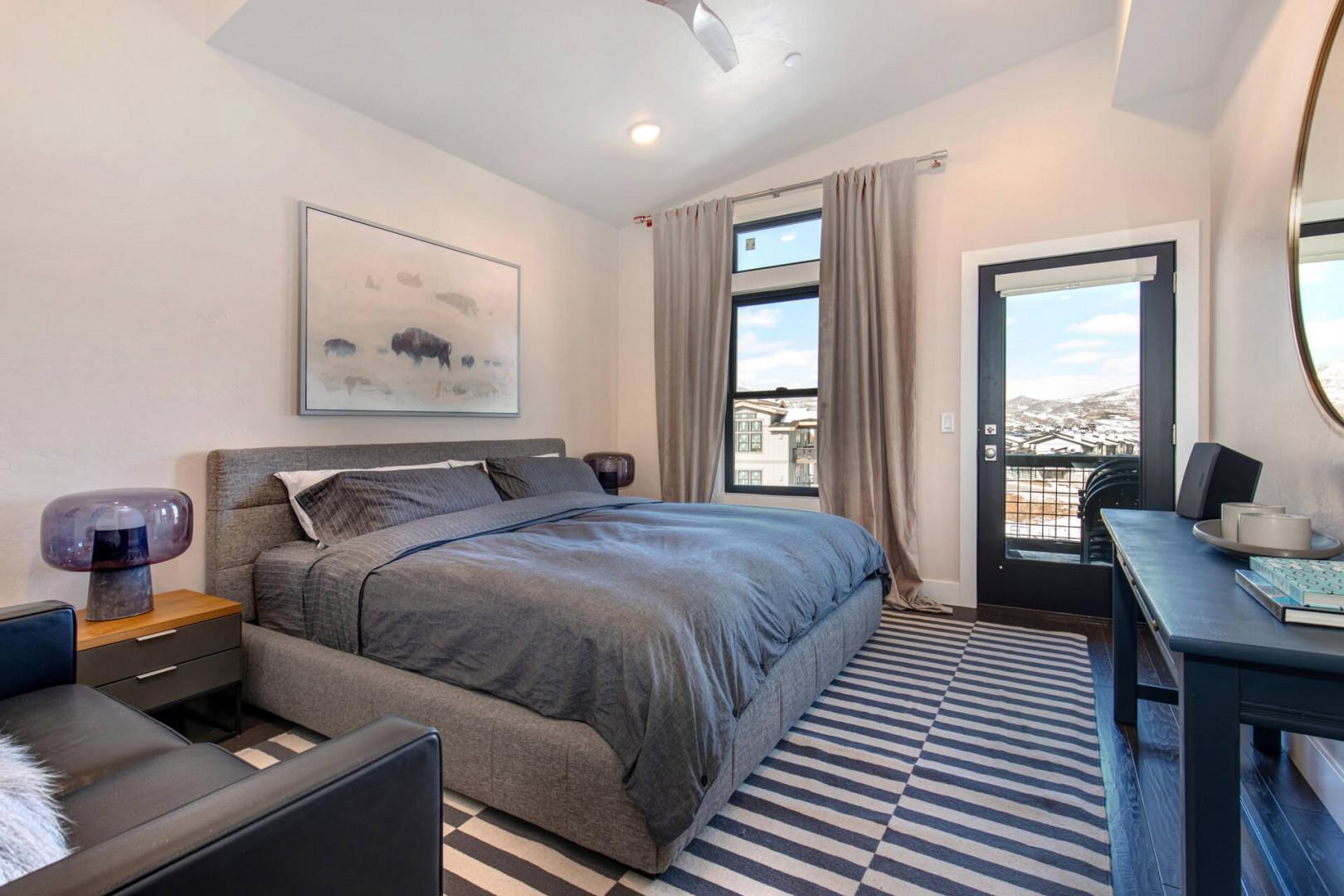 Bedroom "Cozy bed with door opening to serene outdoor patio view."