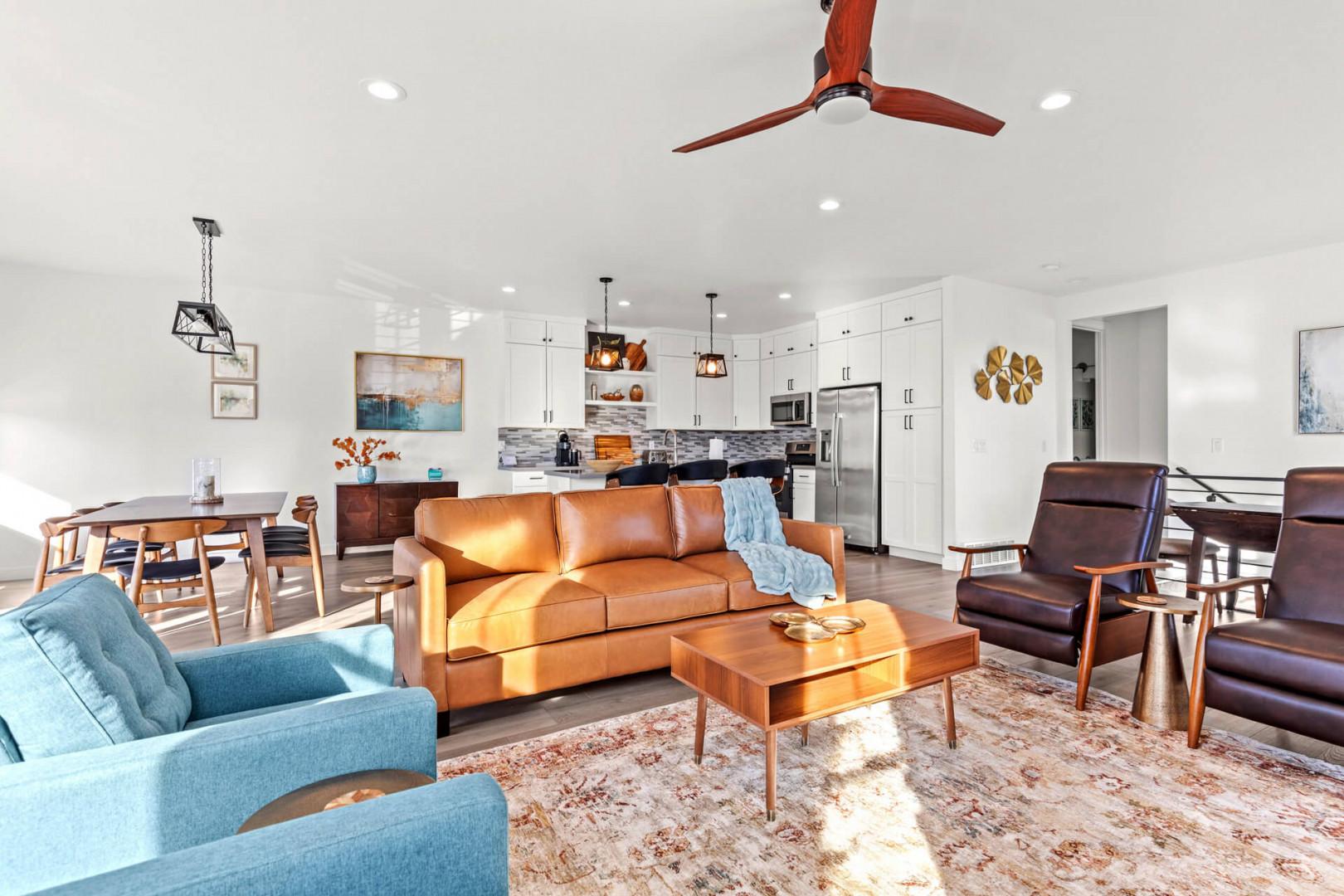 Sink into plush leather seating in your bright open-concept living space, where warm wood tones and thoughtful design create an inviting gathering spot for memorable moments.
