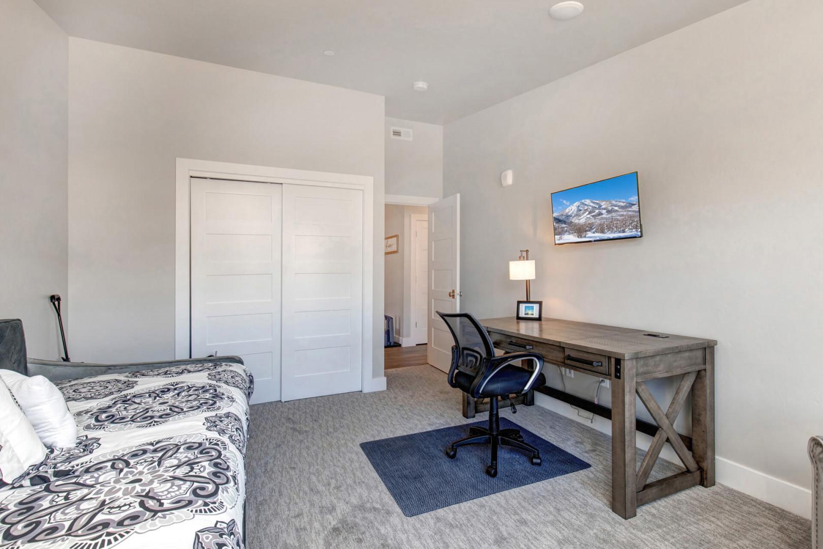 Cozy bedroom with a comfortable bed, desk, and chair.