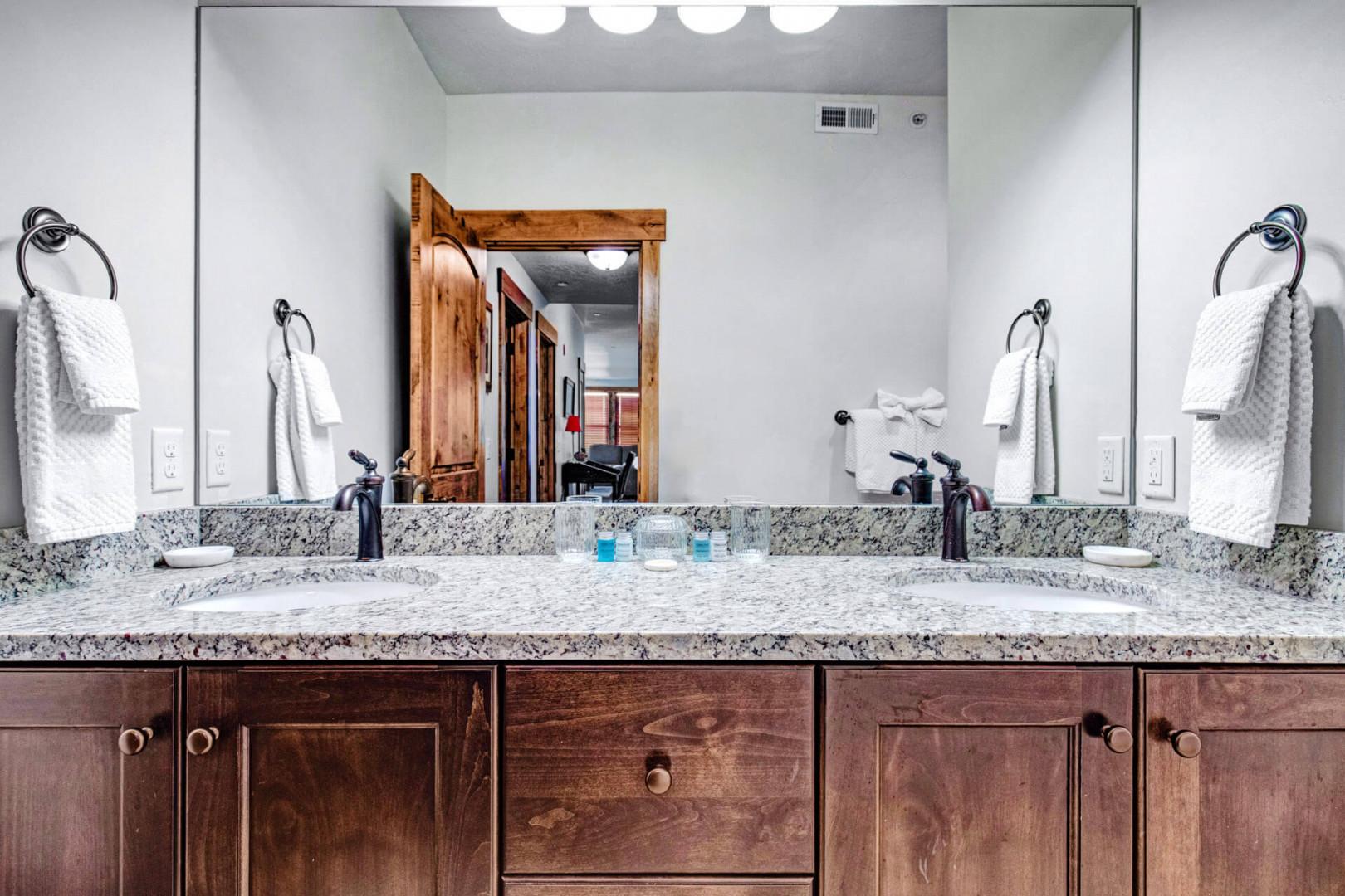 Freshen up at your private double-sink vanity, elegantly designed with granite countertops, rich wood cabinetry, and plush towels ready for you.