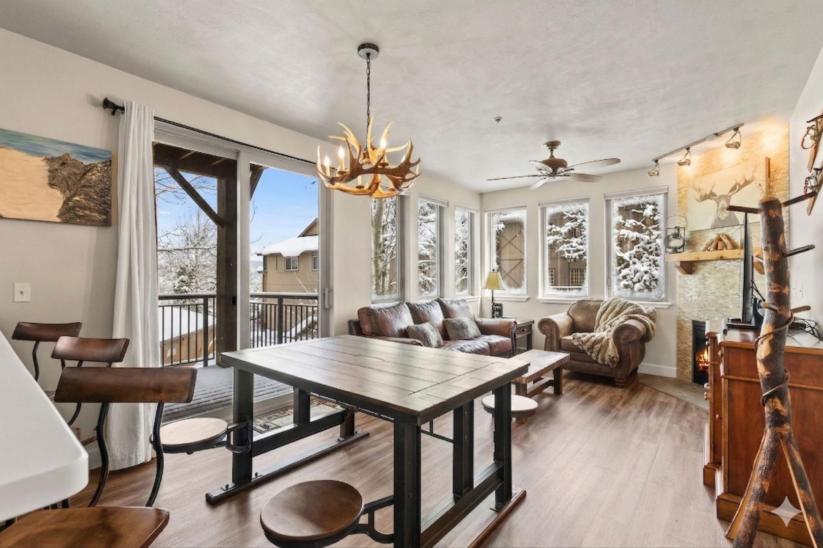 Gather around this rustic dining table with snow-dusted mountain views framing your cozy retreat.