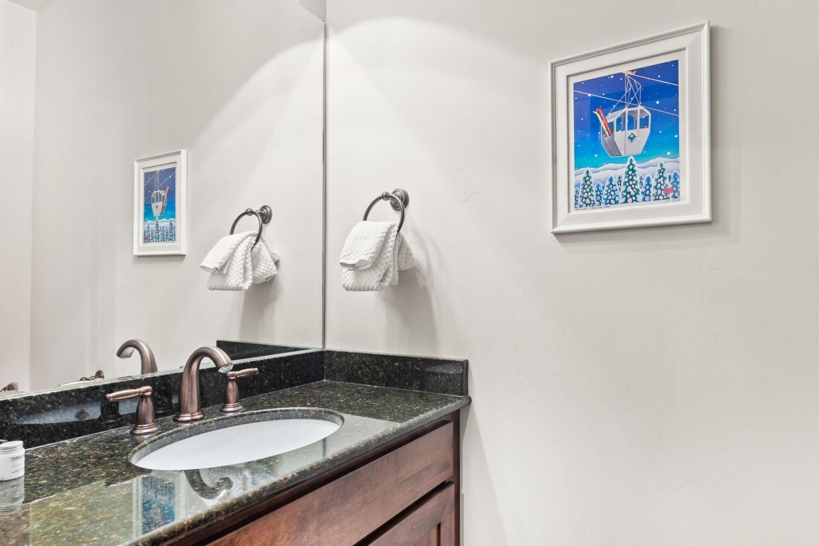 Refresh in your stylish bathroom featuring granite countertops, dual sinks, and charming coastal artwork that adds personality to your morning routine.