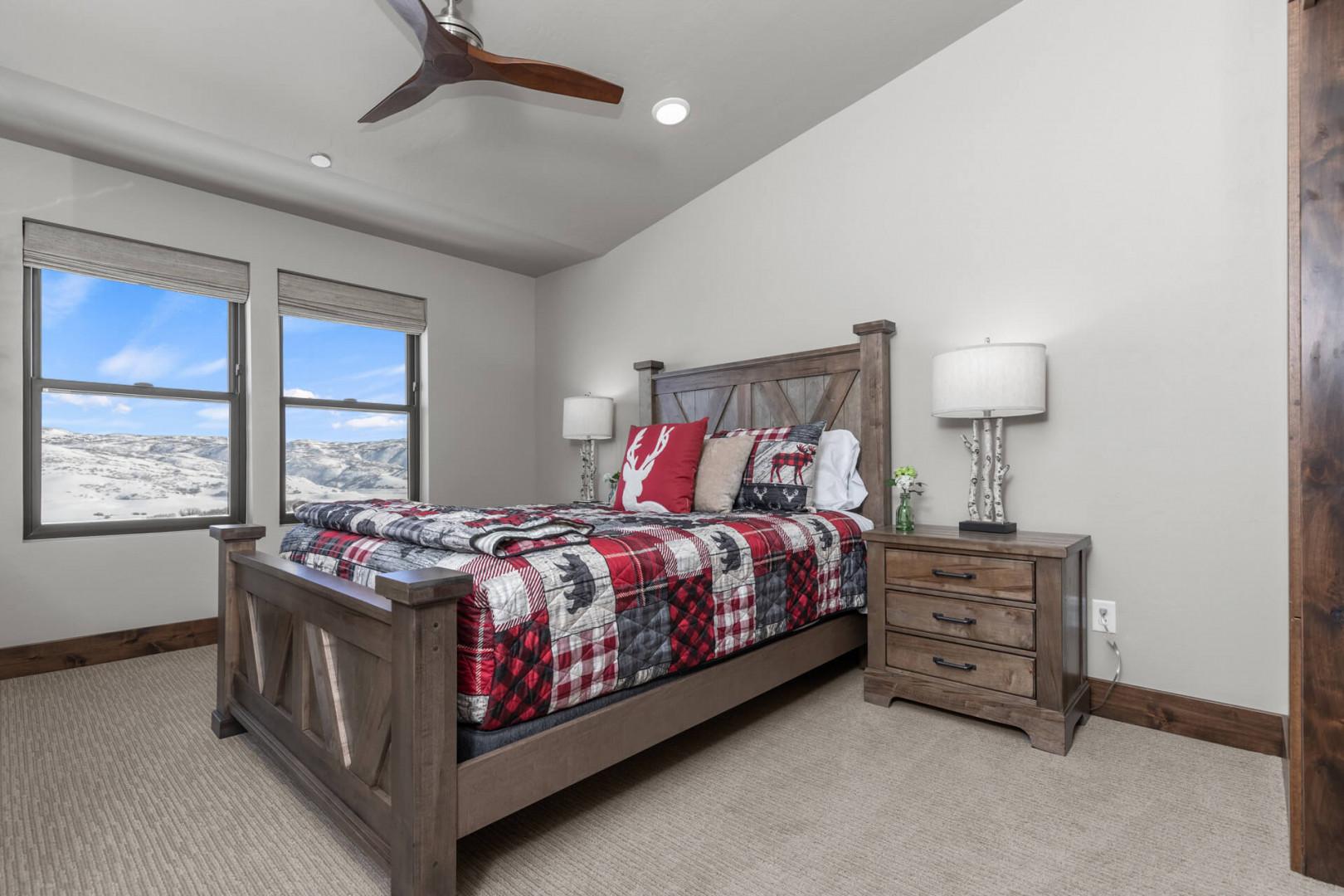 Cozy bed bathed in natural light from the large windows.