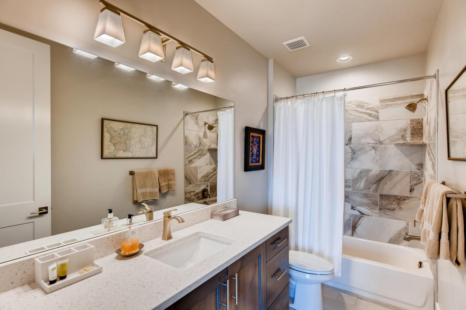 Jordanelle Estates 13299: Sleek sink, mirror, toilet, and convenient tub shower combo.