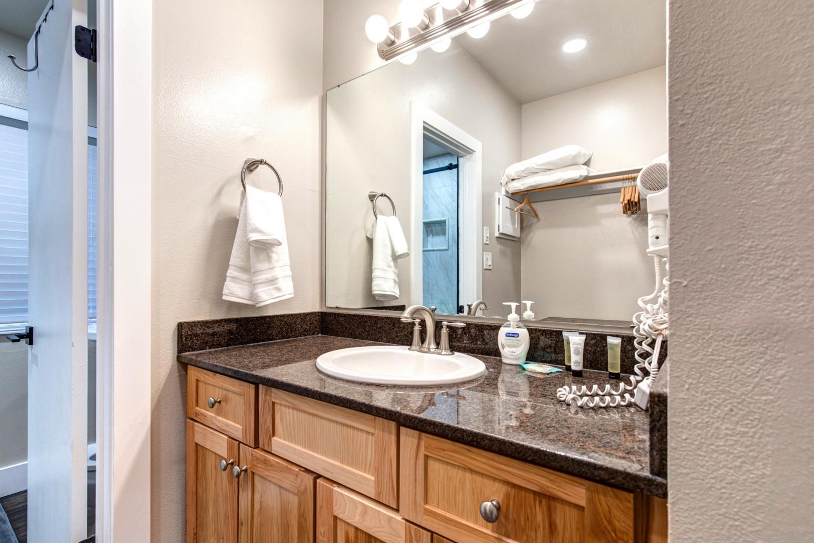 Bathroom: "Sleek sink, hair dryer, and bright overhead lights in modern bathroom."