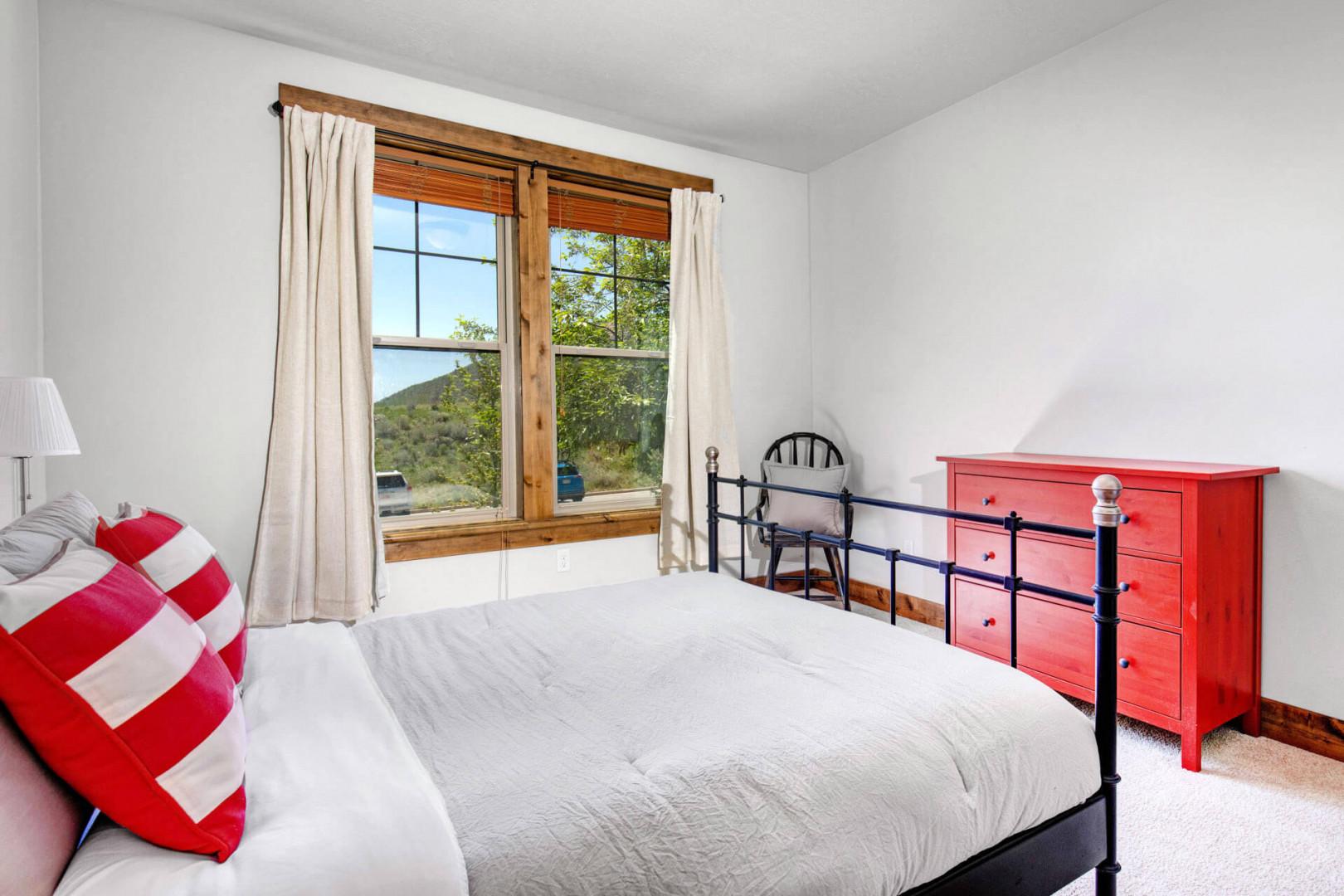Your bright, peaceful bedroom features a comfy bed, natural light through large windows, and hillside views to greet you each morning.