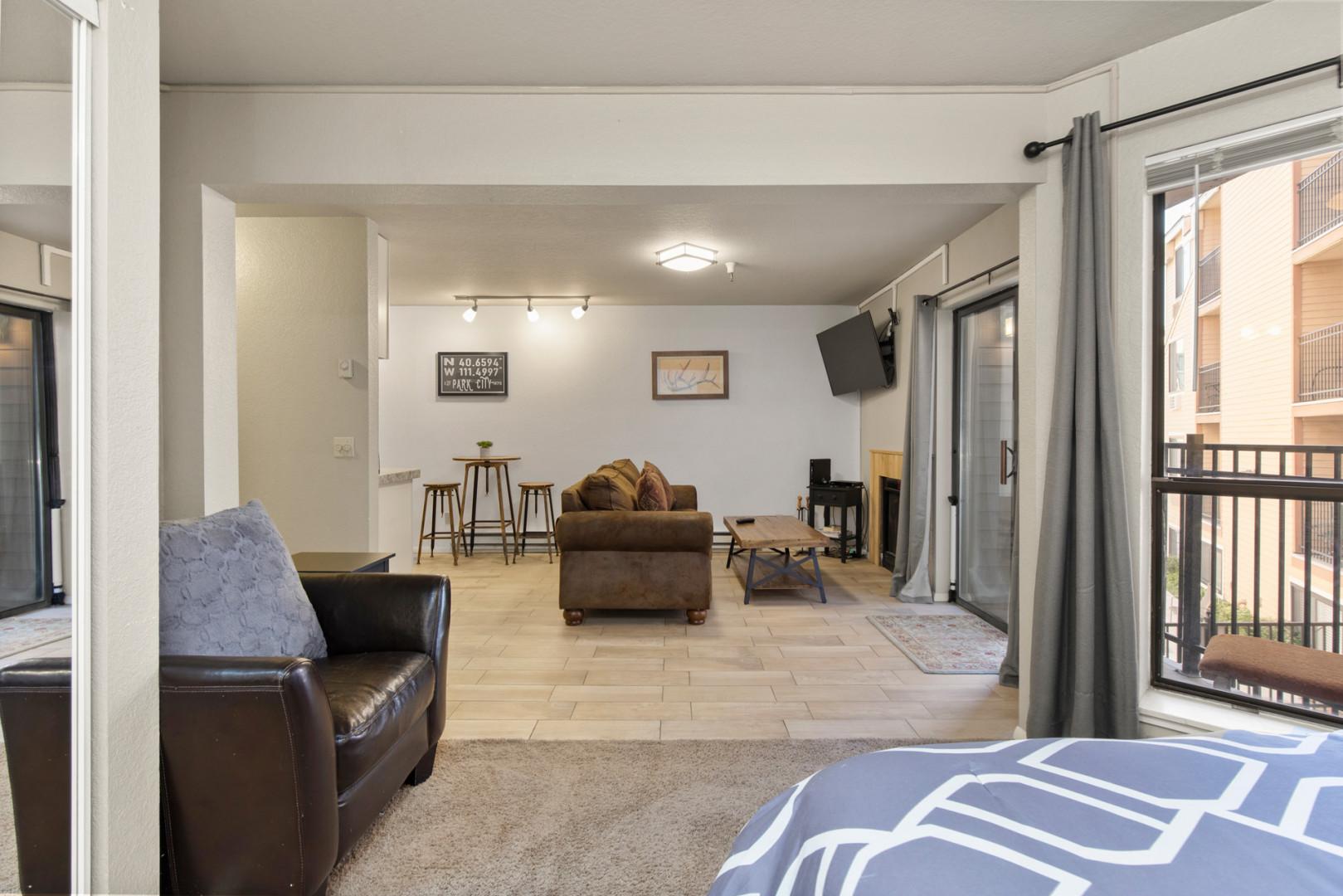 Cozy queen bed offers a view of the inviting living room.