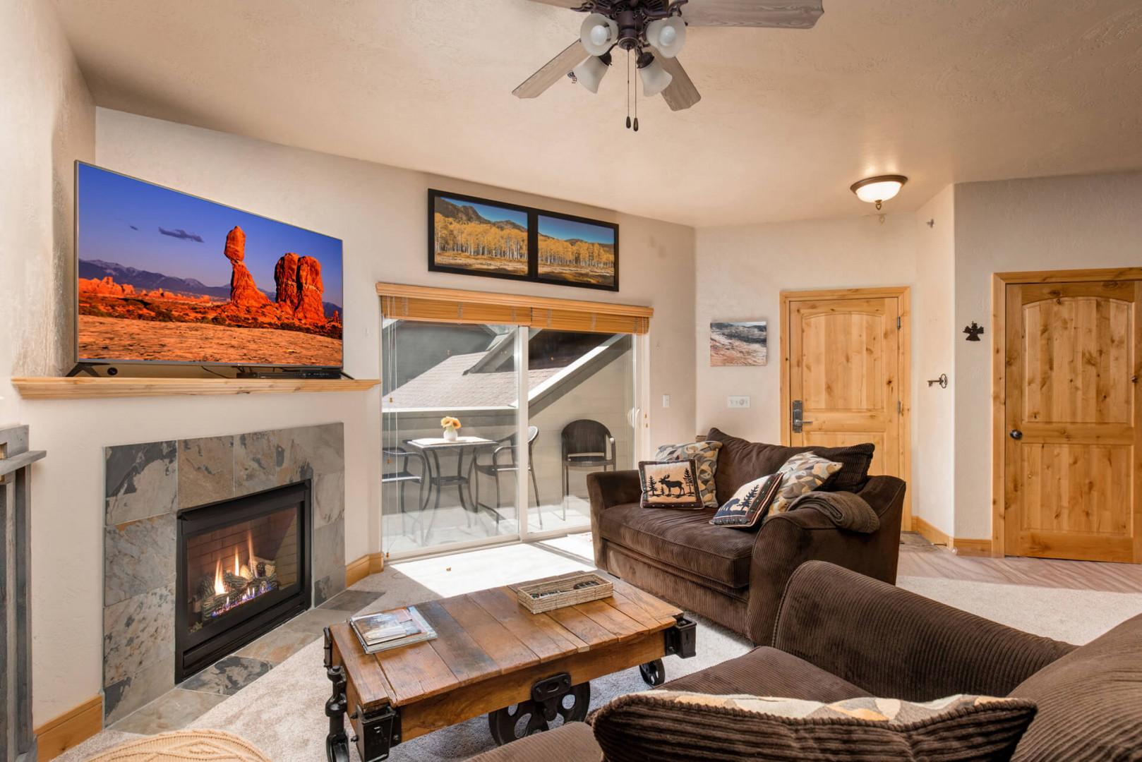 1684 Fox Hollow #H3_21: Cozy sofa set by the fireplace, leading to a charming outdoor patio.