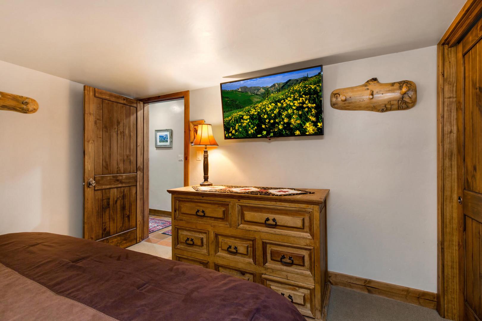 Cozy ambiance with overhead TV and sleek cabinet.