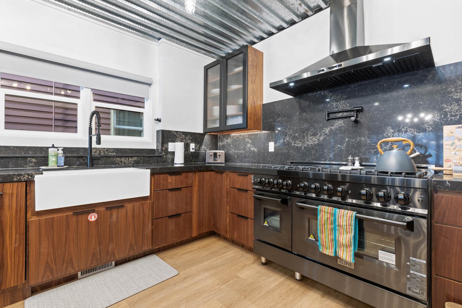 Sleek gas range, ample countertops, and deep sink in spacious kitchen.