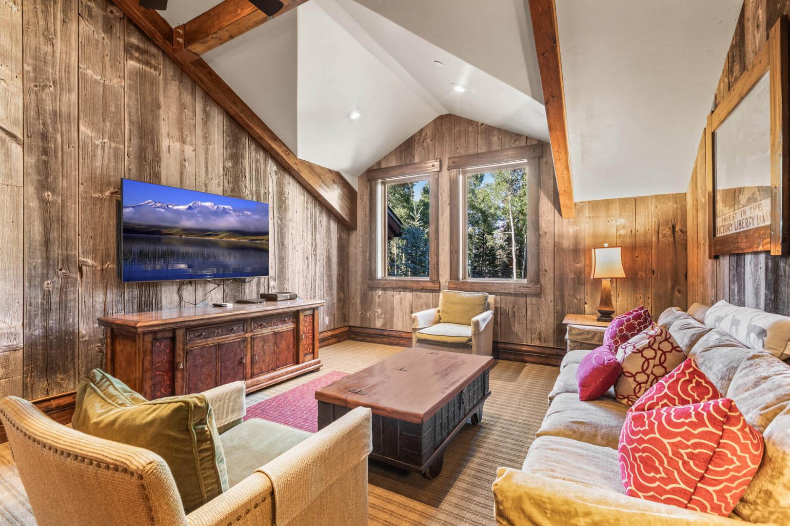 Cozy sofa set, center table, windows, and mounted TV view.