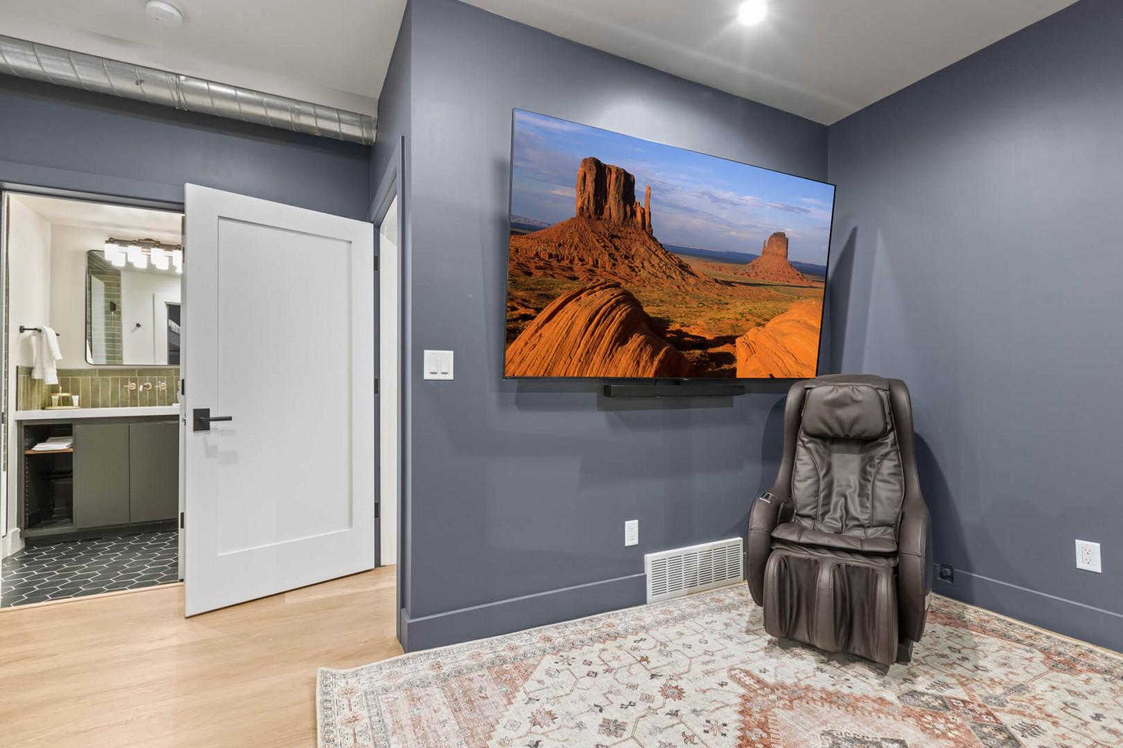 Cozy seating area with a massage chair and entertainment center.