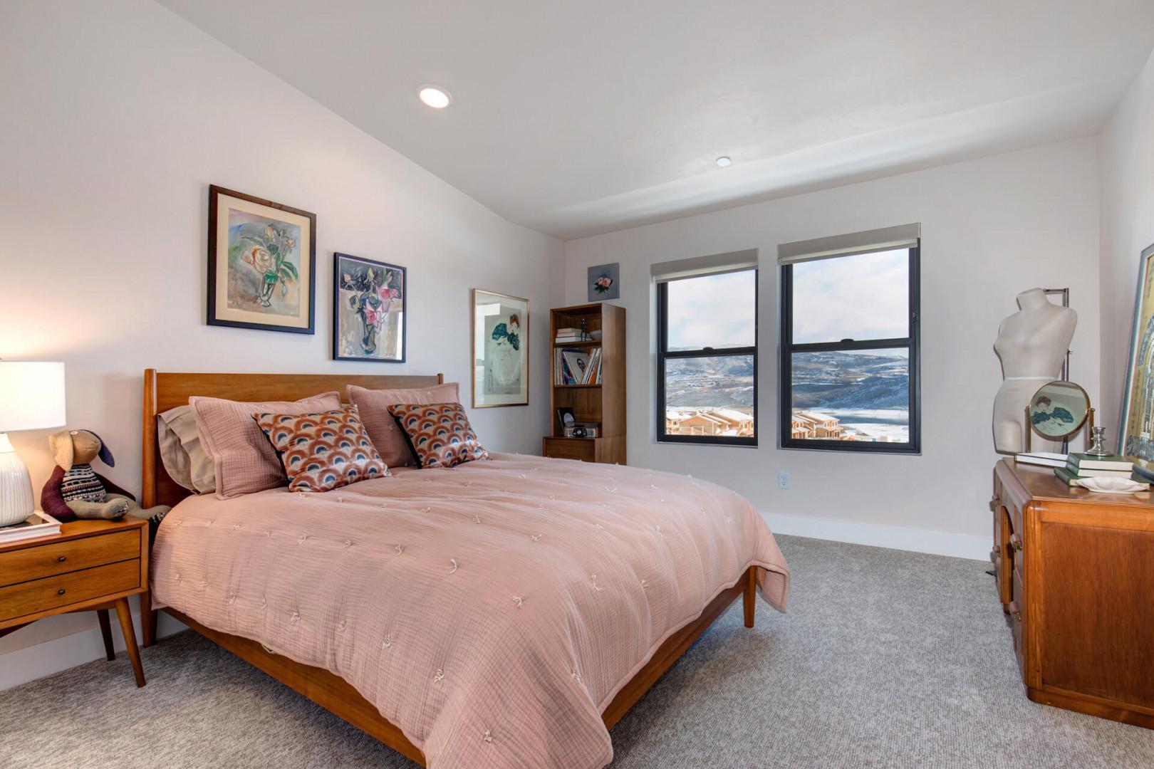 Sunlight streams through windows onto the cozy bed.