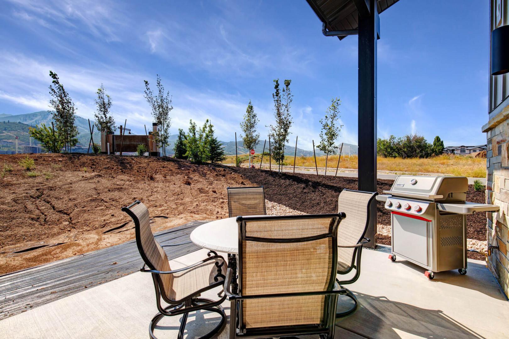 This covered patio offers mountain views and includes a stainless steel grill, perfect for preparing meals while enjoying the fresh air and scenic backdrop.