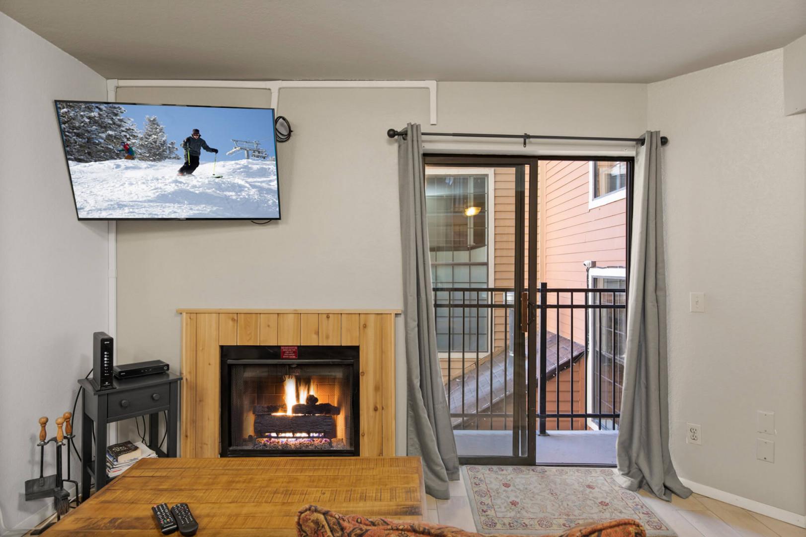 Cozy ambiance with a fireplace and balcony view from the sofa.