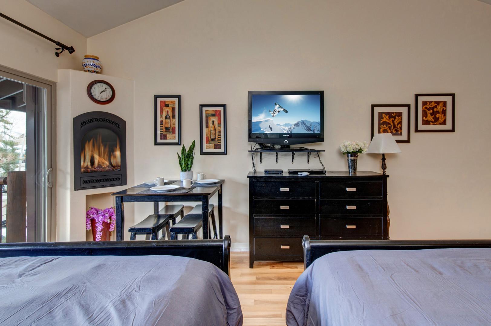 Studio: Cozy space with 2 queen beds, fireplace, dining table, and TV.