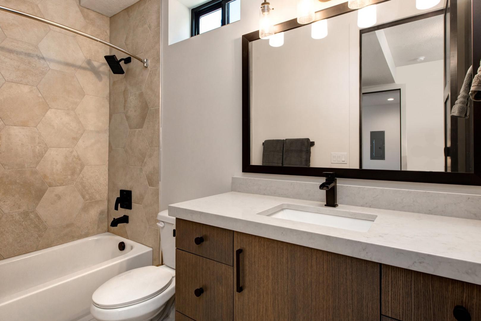 Jordanelle Estates 13201: Sleek sink, mirror, toilet, and convenient tub shower combo.