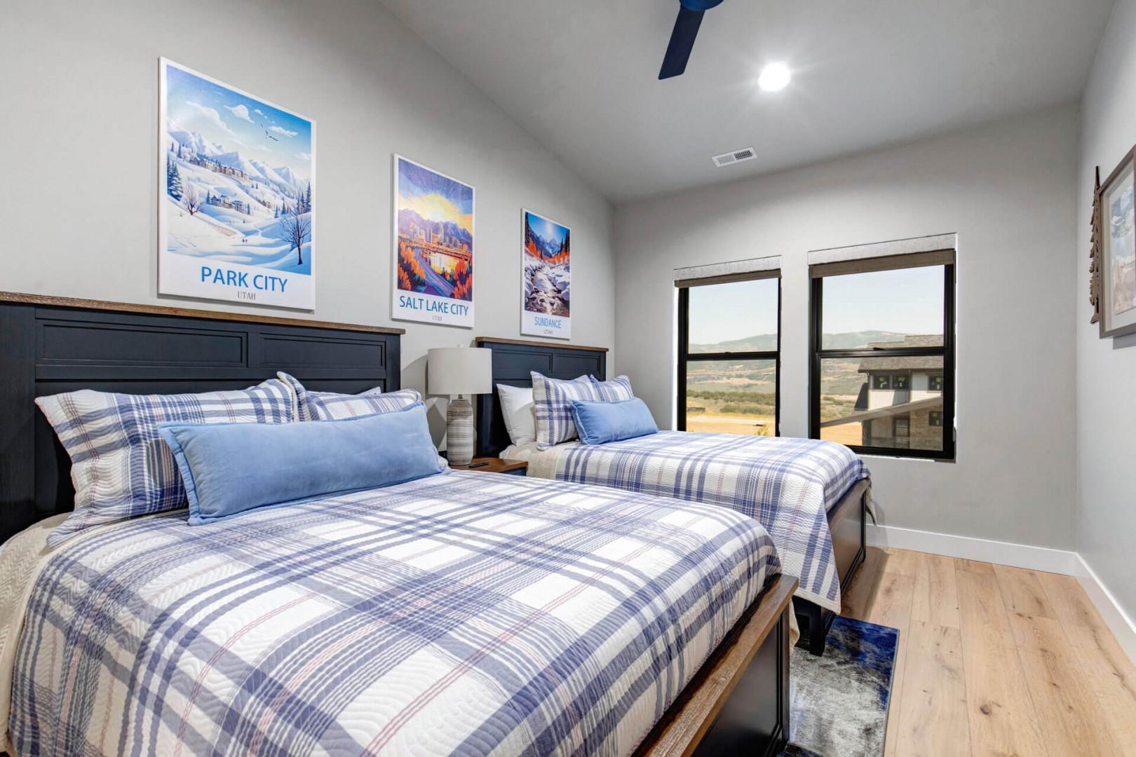 Your comfortable bedroom features two cozy beds and sweeping desert views through large windows, perfect for mountain getaways.
