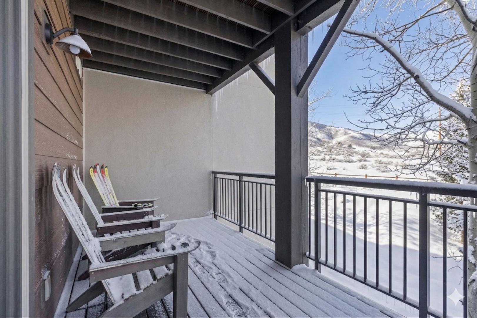 Cozy covered balcony with mountain views where you can relax in comfortable chairs while enjoying the peaceful winter landscape.