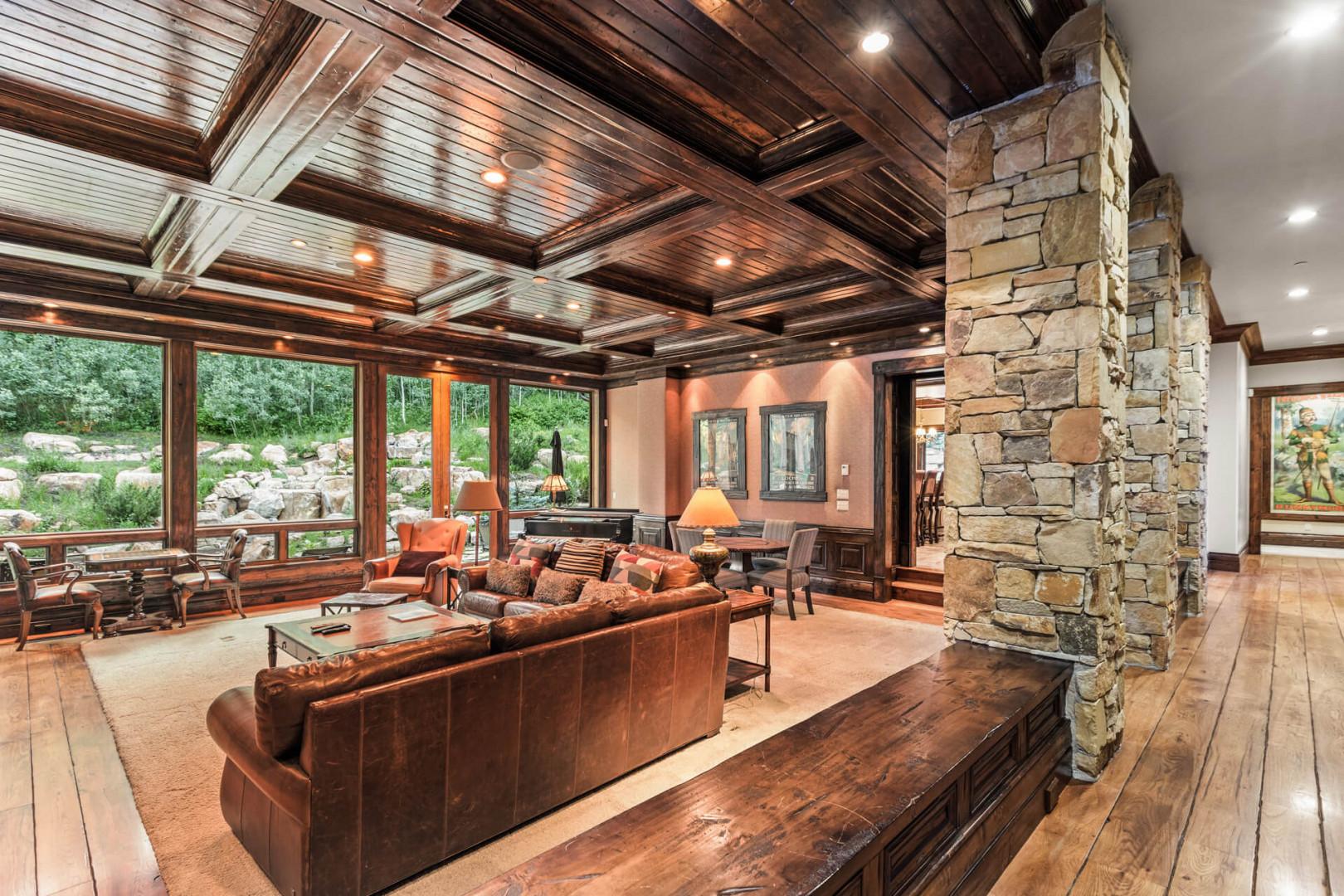 Cozy sofa set, center table, rustic rock beams create inviting ambiance.