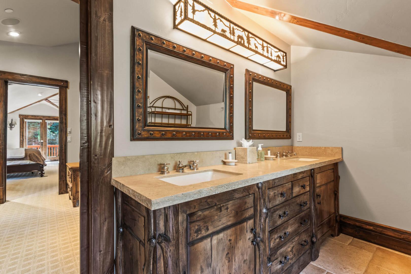 Double sinks, mirrors, cabinets, and bright overhead lights."